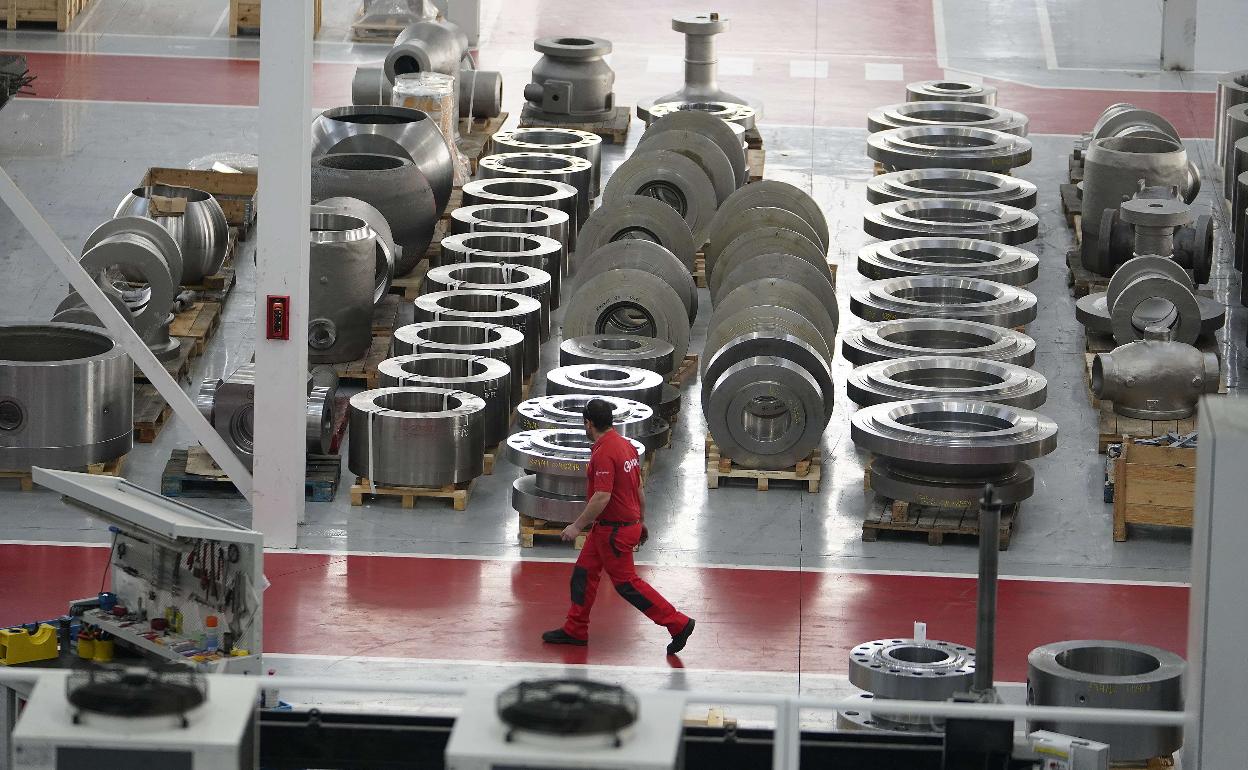 Un operario pasa al lado de válvulas almacenadas en la planta de la cooperativa Ampo en Idiazabal.