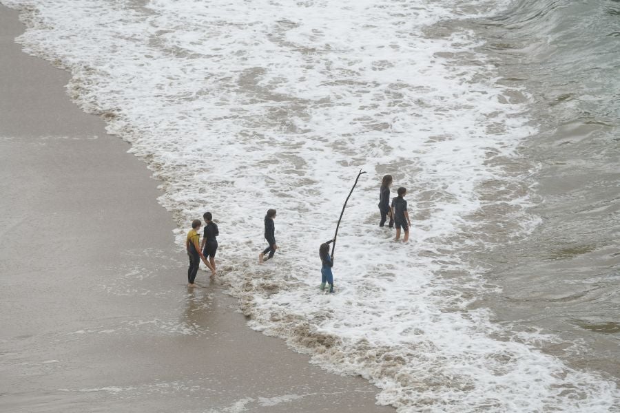 Un grupo de chavales se ha animado a bañarse en la playa de Orio. Eso sí, con neopreno. La temperatura del mar este martes se encuentra a 20,2 º de temperatura.