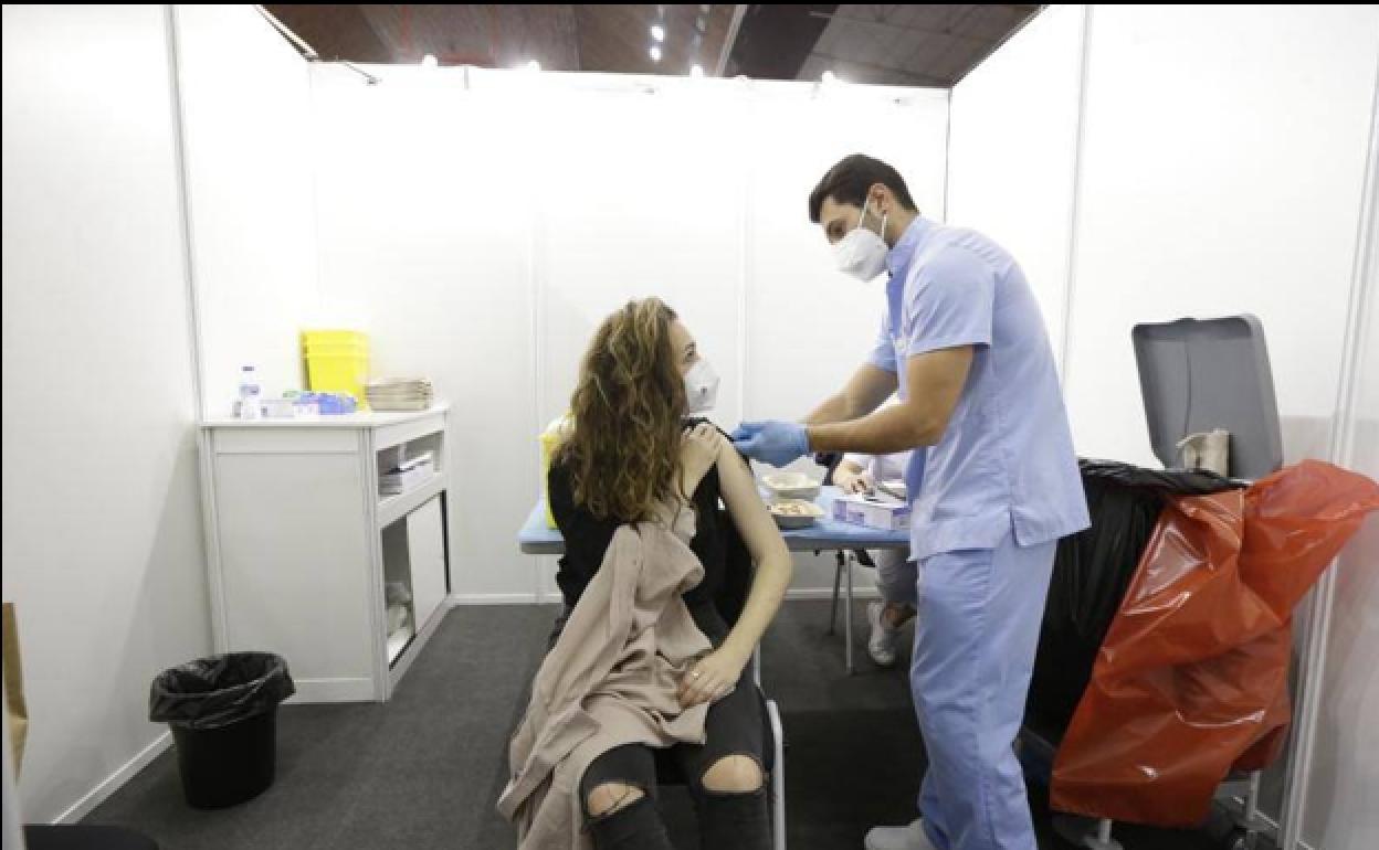 Una joven perteneciente a un colectivo esencial recibe la vacuna contra el coronavirus.