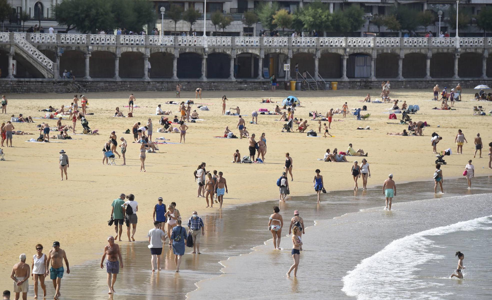 Personas paseando por la playa de La Concha.