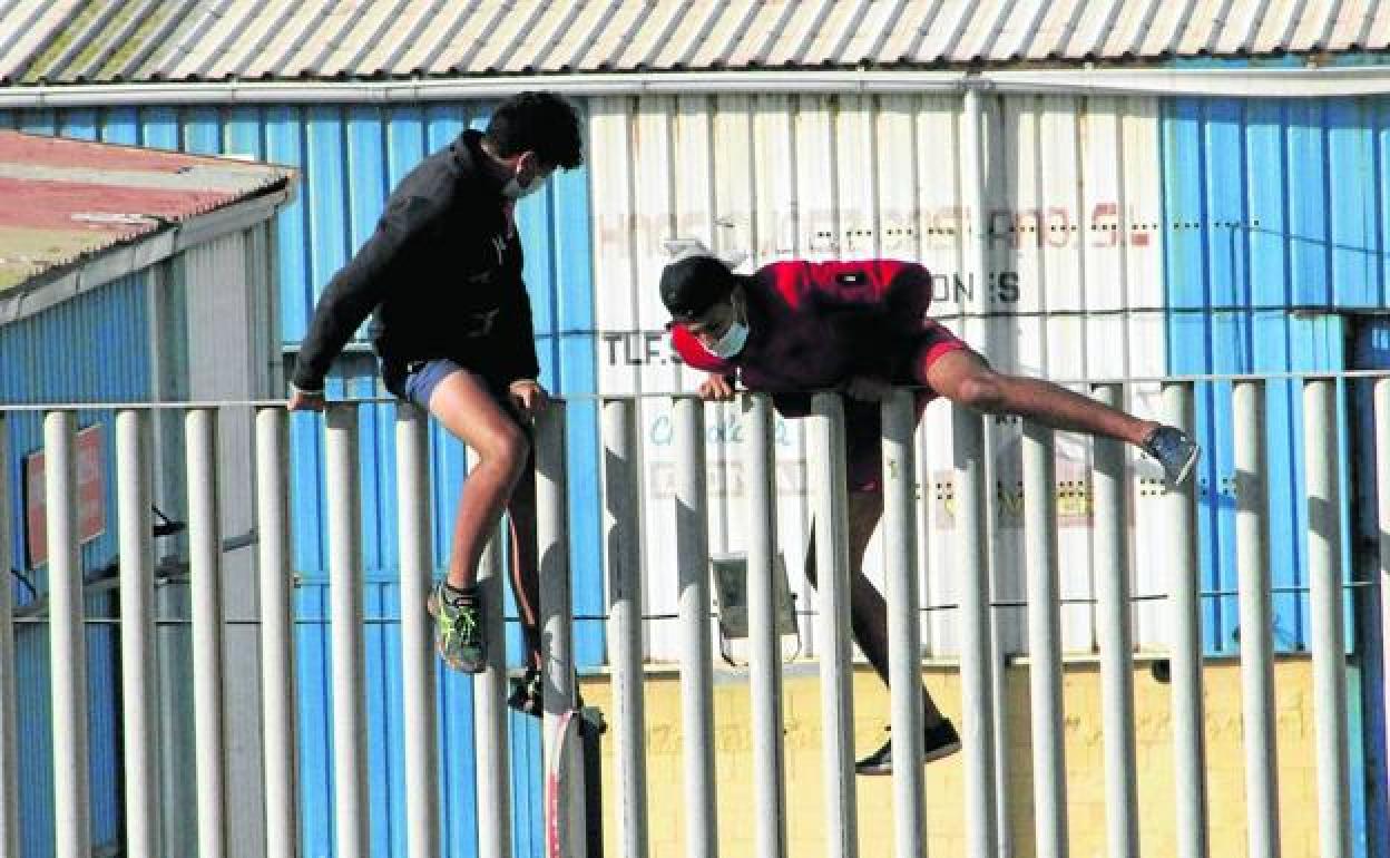 Dos jóvenes tratan de escapar del centro del Tarajal, en Ceuta, para no ser repatriados a Marruecos.