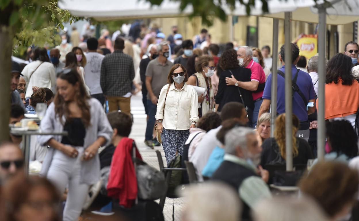 Una mujer camina entre terrazas en el centro de Donostia