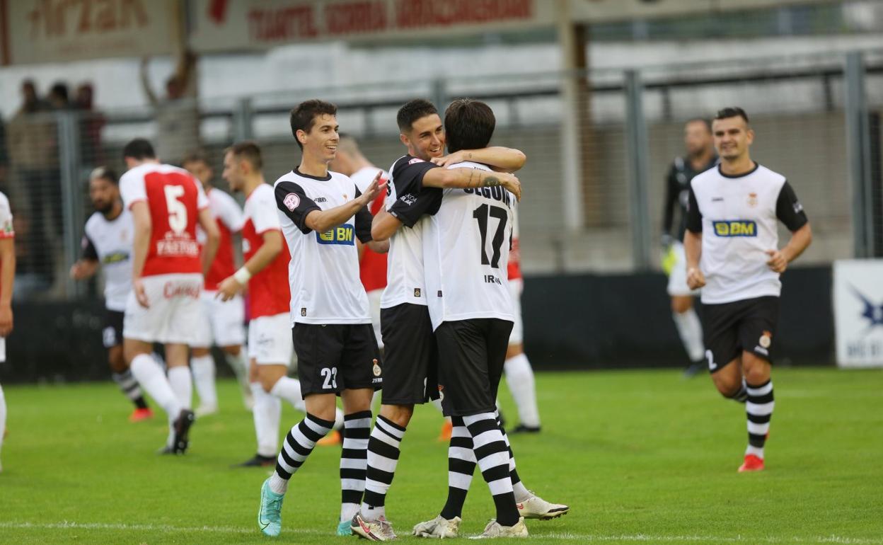 Nacho Sánchez y Sergio Llamas felicitan a Aitor Seguín esta pretemporada, en el encuentro amistoso ante el Racing de Santander. 