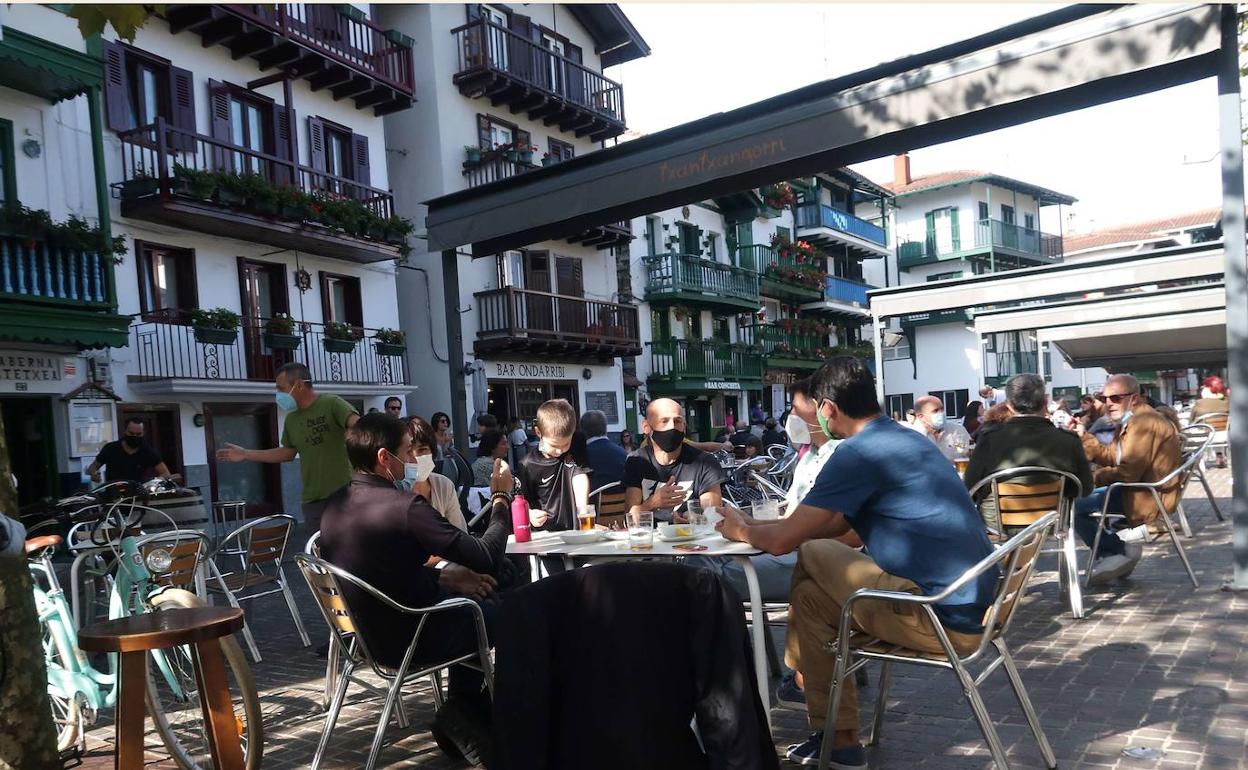 Varios grupos de personas disfrutan del aperitivo en Hondarribia. 
