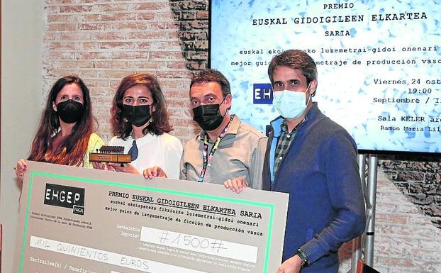 Maider Oleaga, de blanco, sostiene el premio concedido por los guionistas vascos por el mejor guion.