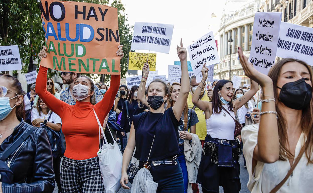 Varias mujeres sostienen diferentes pancartas en una marcha con motivo del Día Mundial de la Salud Mental,