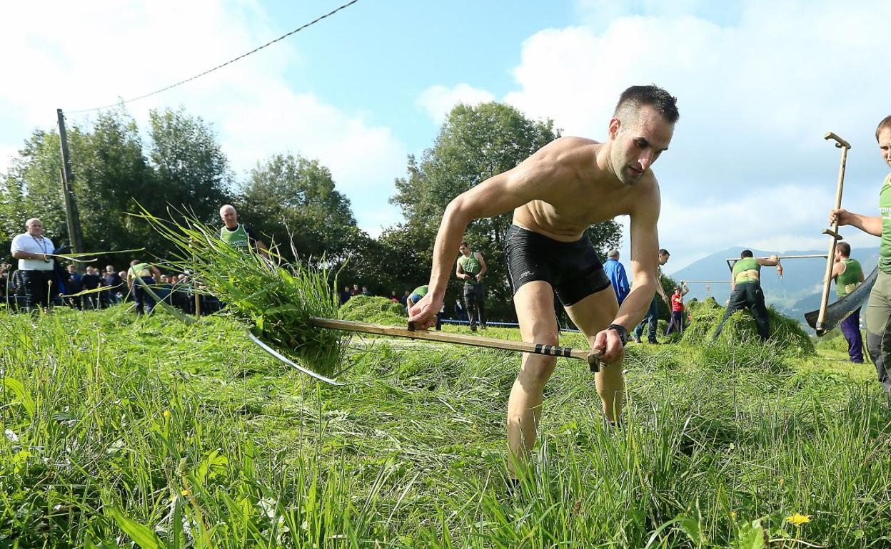 El hernaniarra Iñigo Merkader, cortando la hierba en presencia de su ayudante, Suharri Irazustabarrena, ayer en Xoxoka (Urnieta). 