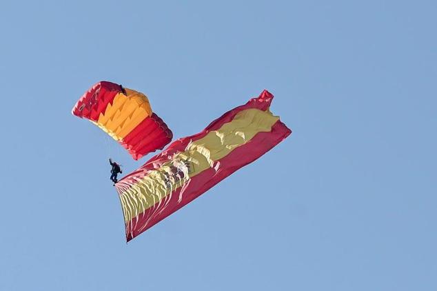 Un paracaidista de la Patrulla Acrobática de Paracaidismo del Ejército del Aire salta sobre la plaza de Lima, en el Paseo de la Castellana.