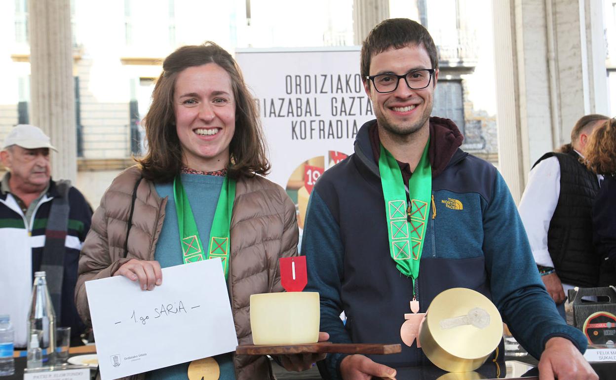 La oñatiarra Irati Usandizaga y Julen Arburua sostienen en sus manos el queso ganador y los galardones del primer premio. 