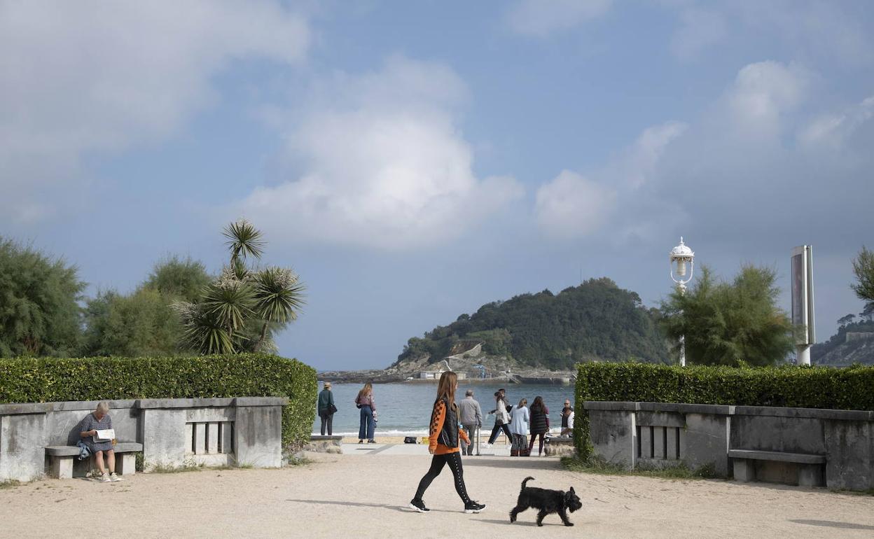 Varias personas pasean cerca de la playa de Ondarreta de Donostia. 