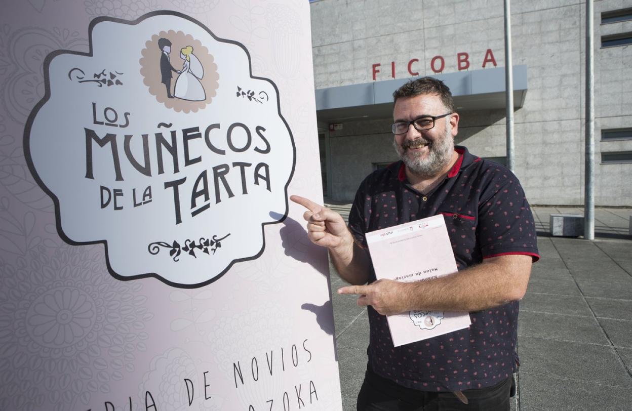 Fernando Vergara, expositor y coorganizador de 'Los muñecos de la tarta', con el cartel de la feria. 