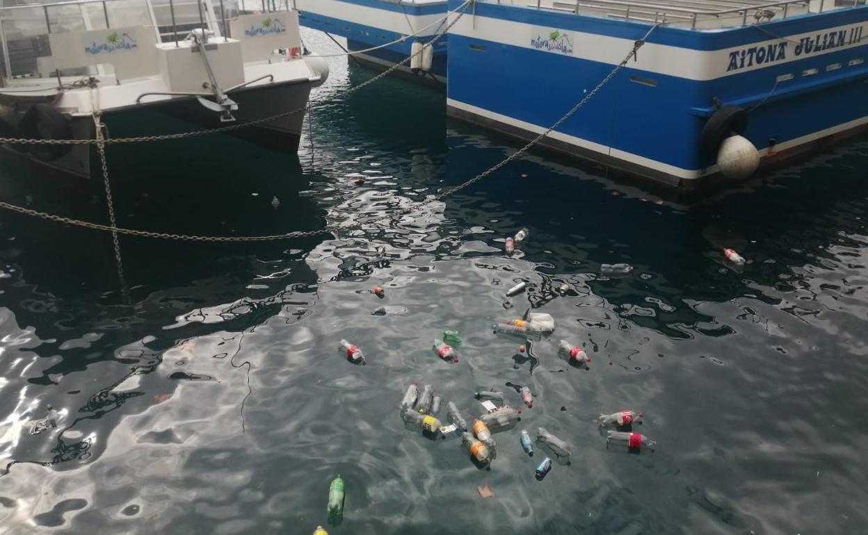 Restos del botellón registrado anoche en el Muelle donostiarra que este lunes han aparecido en las aguas del Puerto. 