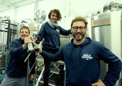 Imagen secundaria 1 - Sobre estas líneas, Jone Irizar y su padre Santos, del caserío Muno; Rubén Irisarri y sus compañeros de Mala Gissona en la fábrica donde producen la cerveza y Begoña Julián de Goxorrubi en su huerta de Altza