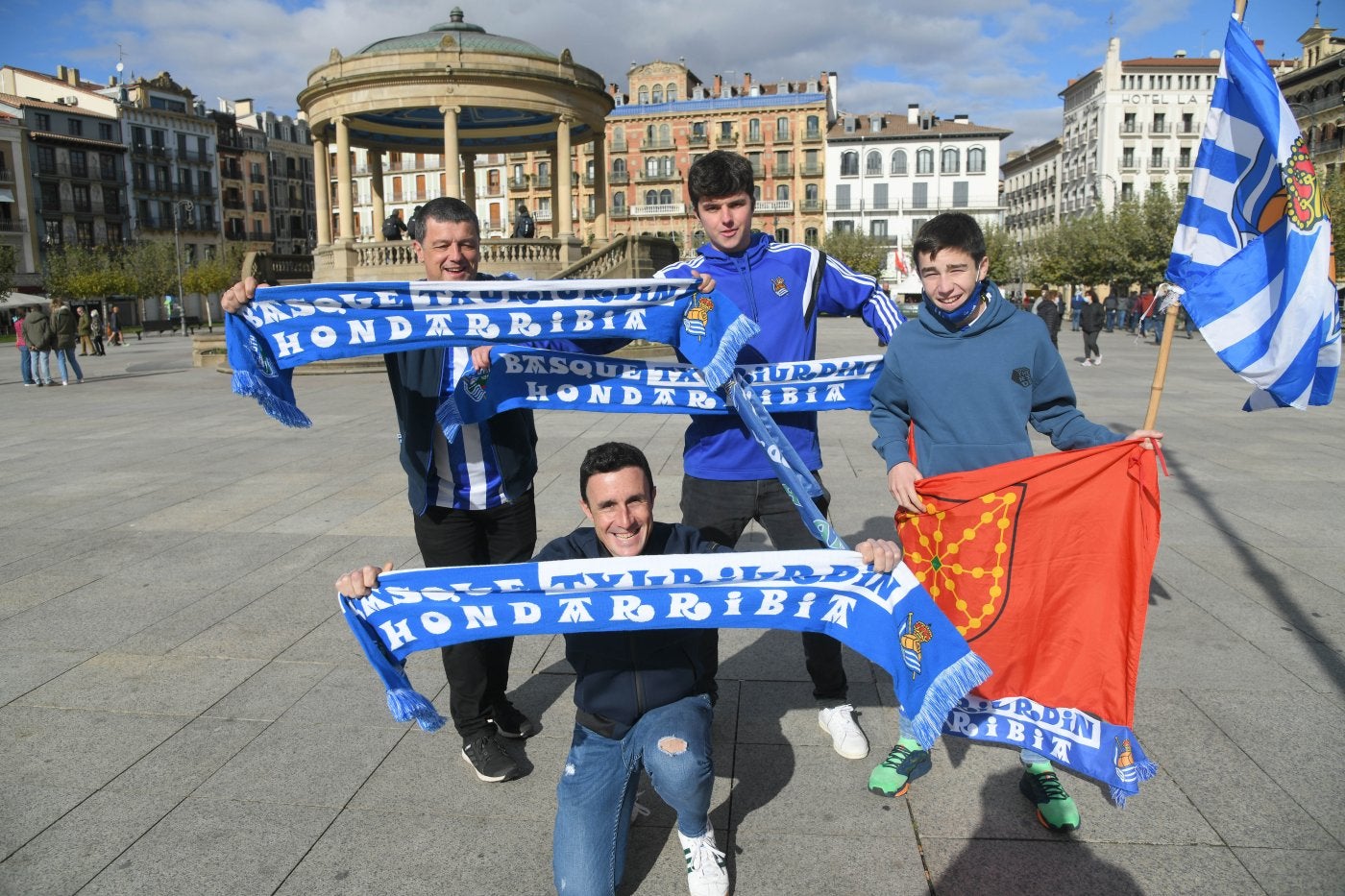 El patrón de la trainera de Hondarribia, Ioseba Amunarriz, agachado, con aficionados en la plaza del Castillo. 