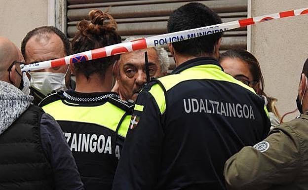 El marido de la dueña del bar es calmado por los agentes. 