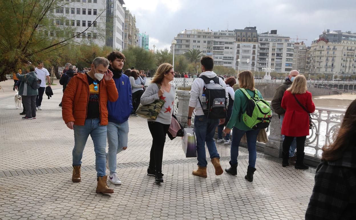 Paseantes con y sin mascarilla por La Concha, en Donostia