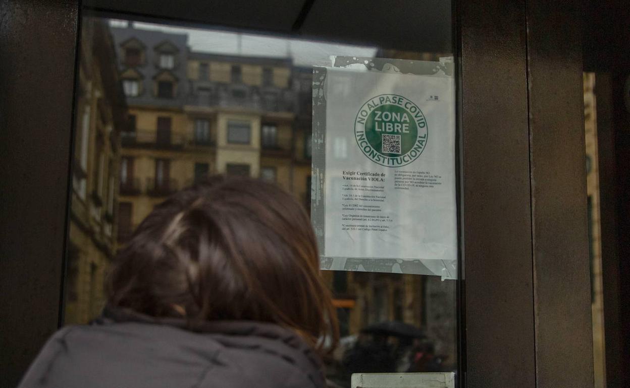 Una clienta observa el cartel que ha colocado la responsable de The Hole en Donostia. 
