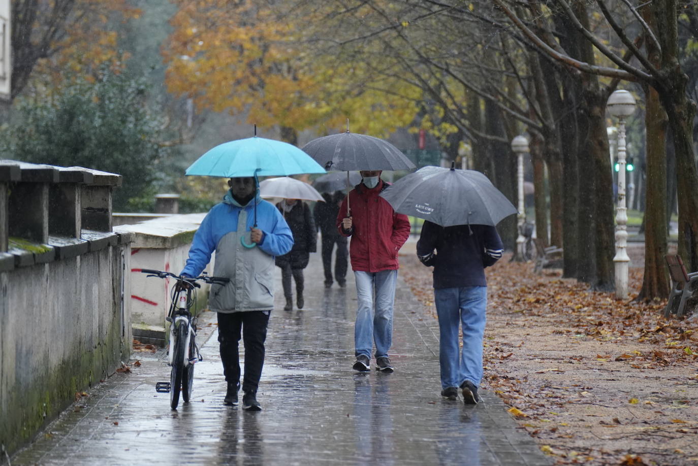 Paseantes bajo sus paraguas en el barrio de Amara, en Donostia. 