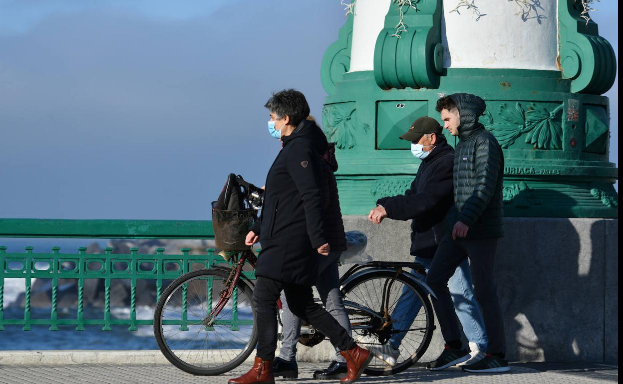 Varios ciudadanos cruzan el puente, algunos con mascarilla.