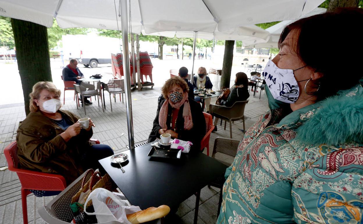 Varias amigas toman un café en una terraza.