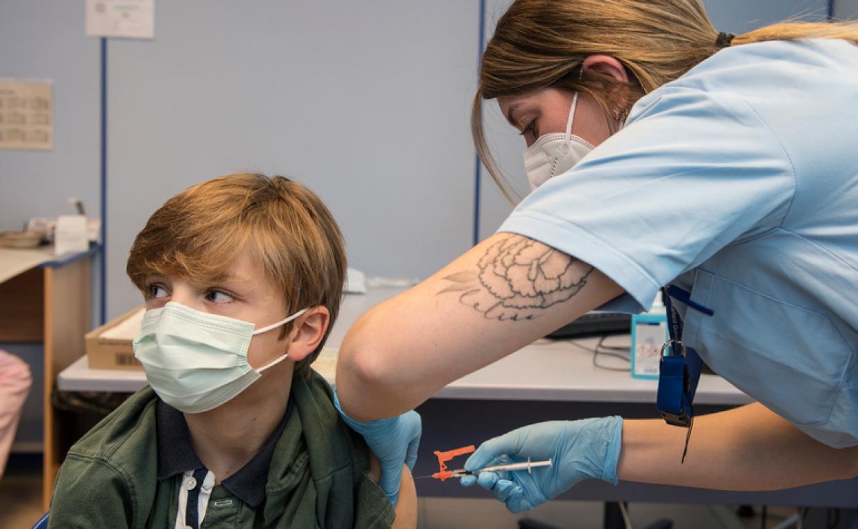 Un niño recibe la vacuna el primer día de vacunación.