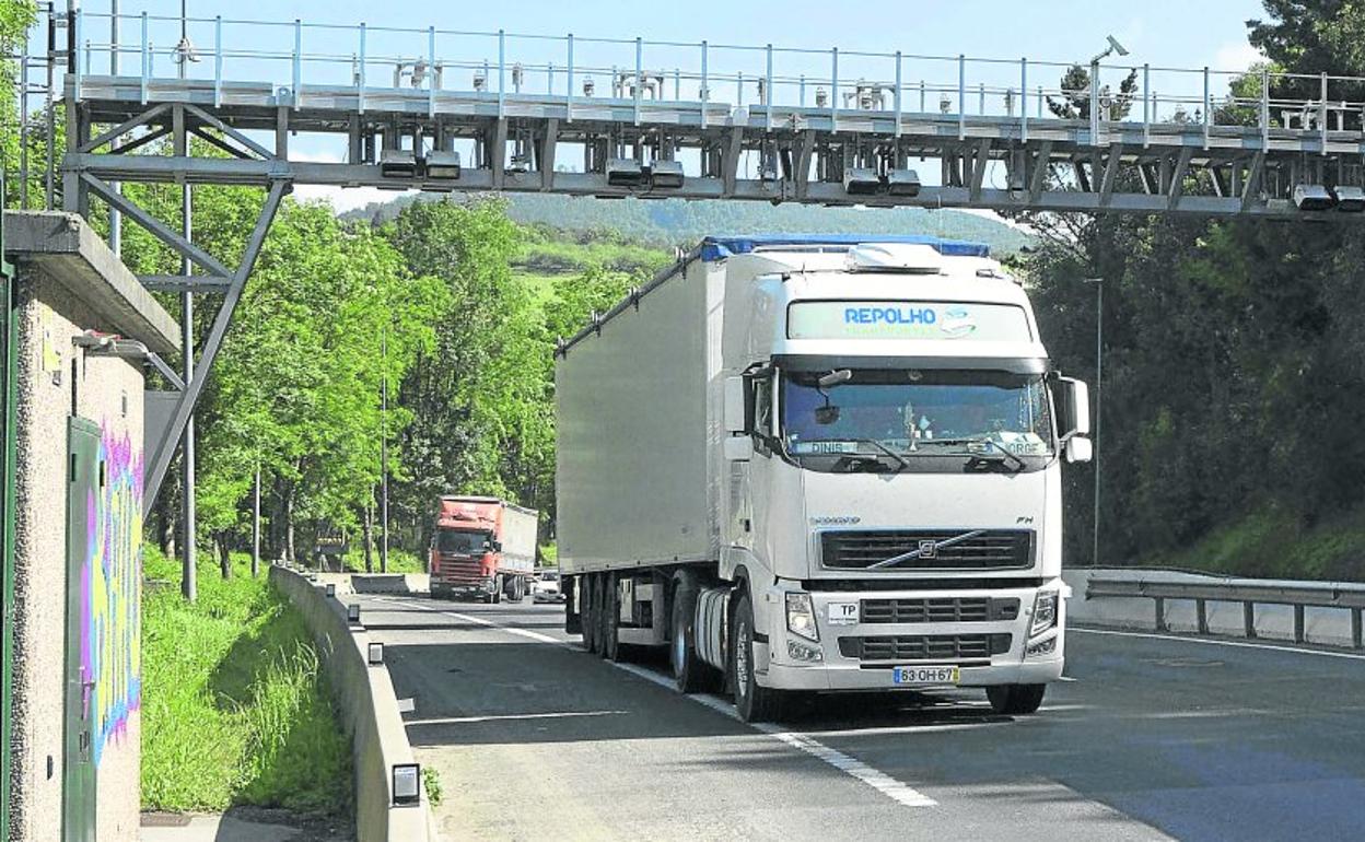 Dos camiones pasan por debajo de uno de los arcos de peaje situados a la altura de la localidad de Andoain. 