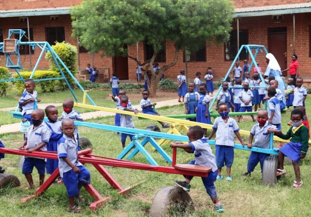 Niños y niñas de la escuela de Kabuga (Ruanda), jugando en los columpios. 