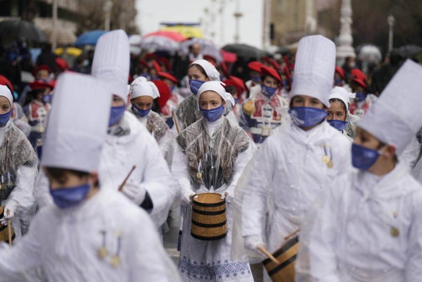 Integrantes de la compañía de Zurriola Ikastola, protegidos con plásticos, durante el desfile. 
