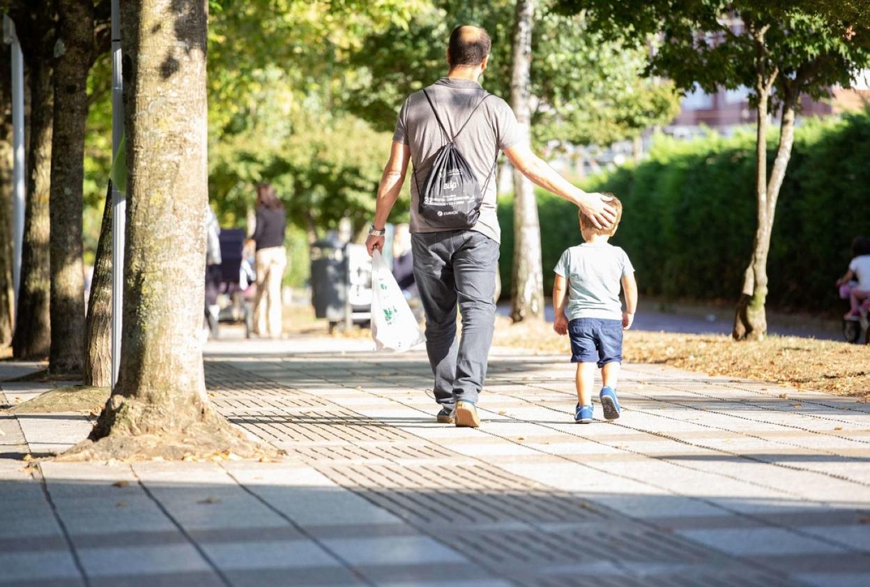 Un padre pasea con su hijo menor por una calle de Donostia. 