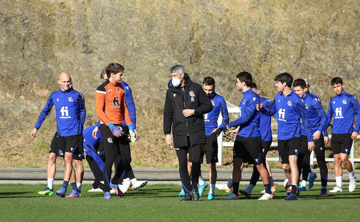Imanol Alguacil habla con Álex Remiro mientras el resto de la plantilla charla en el entrenamiento de Zubieta