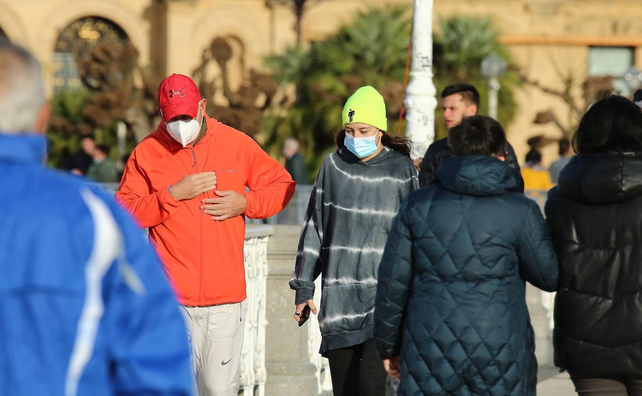 Ciudadanos con mascarillas en el paseo de La Concha.