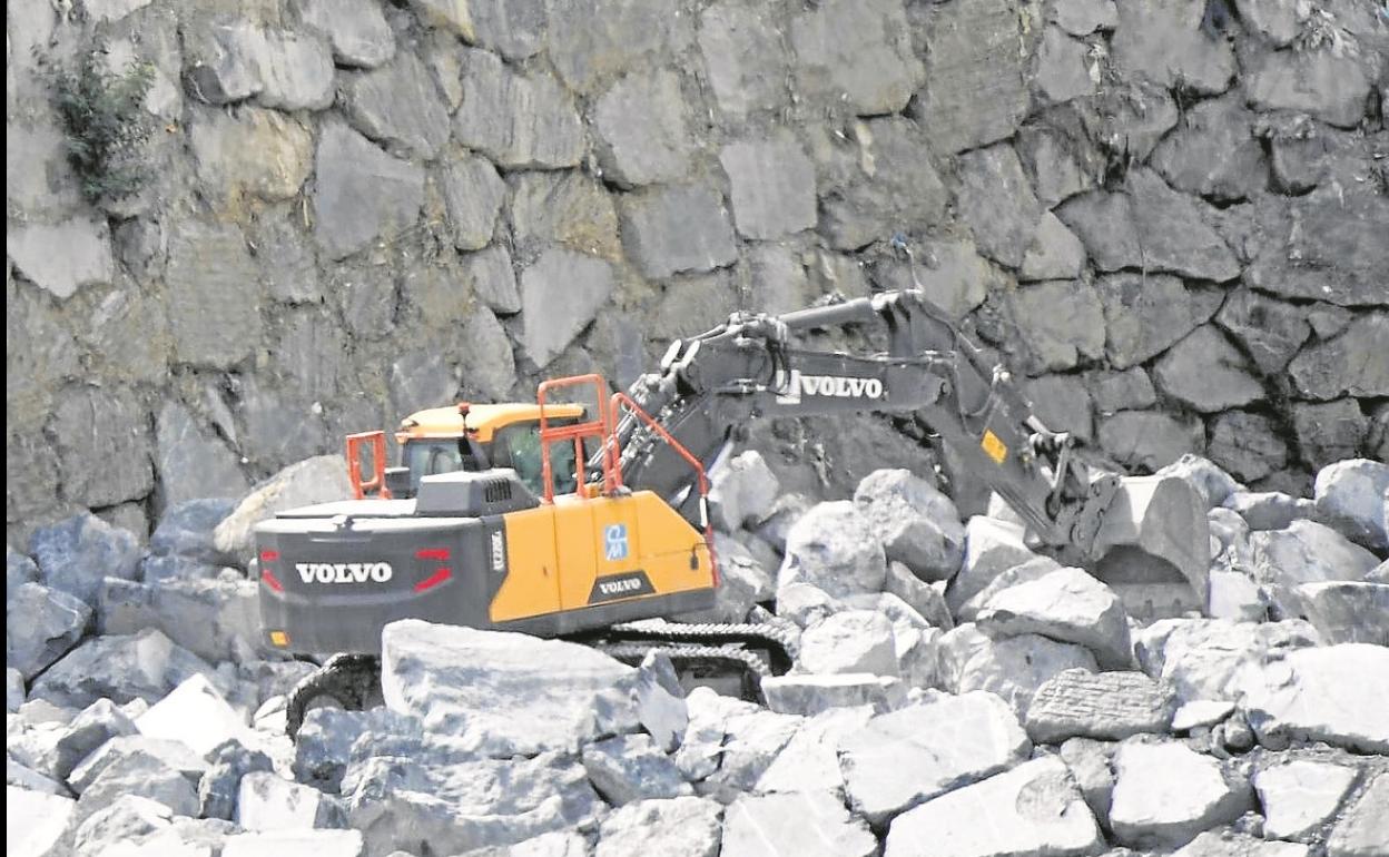 Una excavadora trabaja en la construcción del muro.