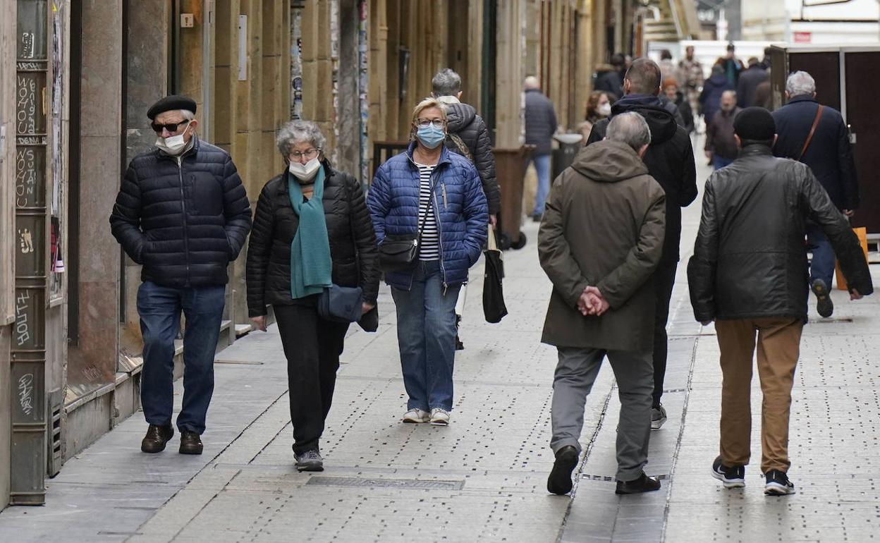 Varios viandantes pasean por la Parte Vieja donostiarra haciendo uso de la mascarilla.