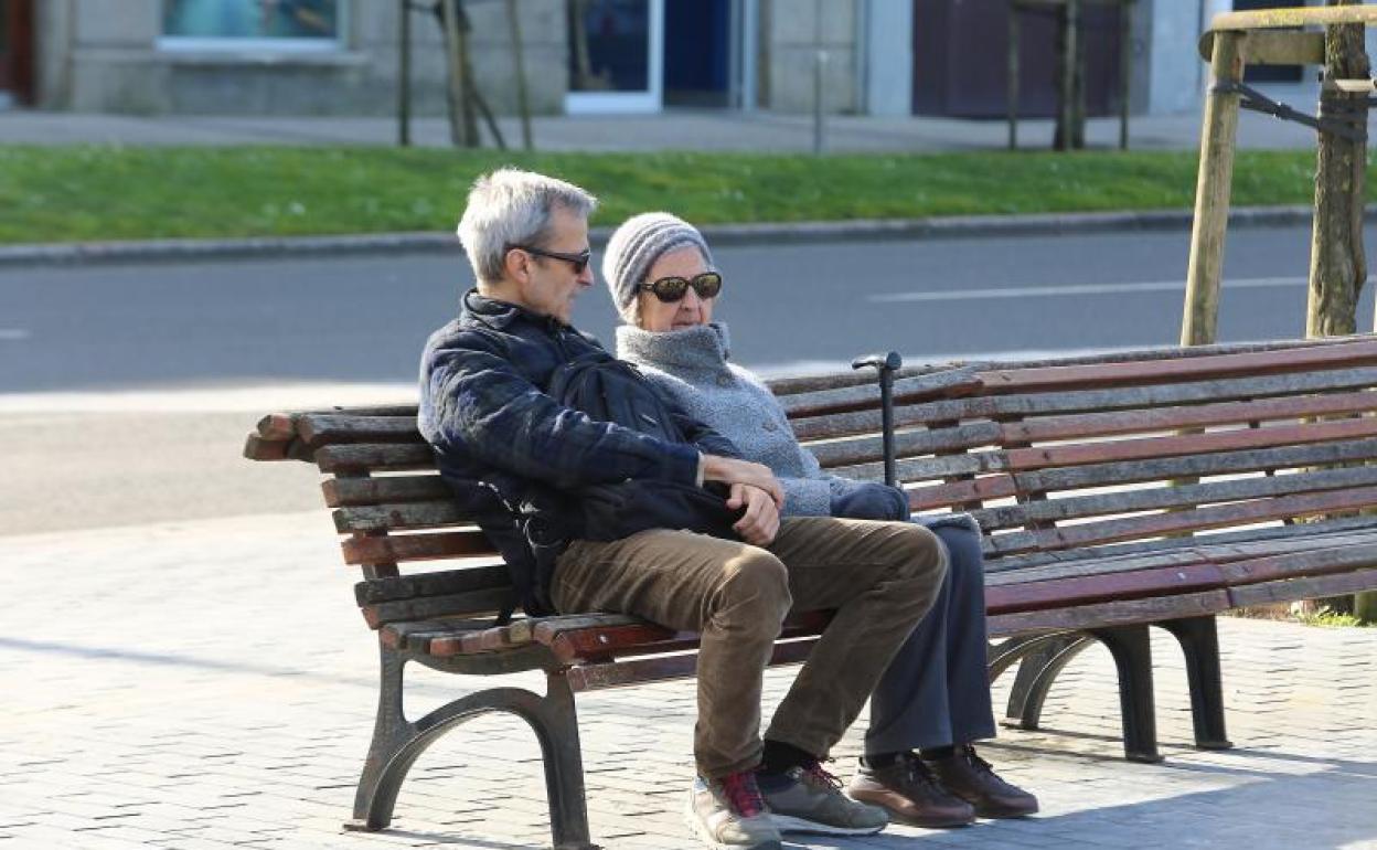 Una pareja sentada en un banco en San Sebastián. 