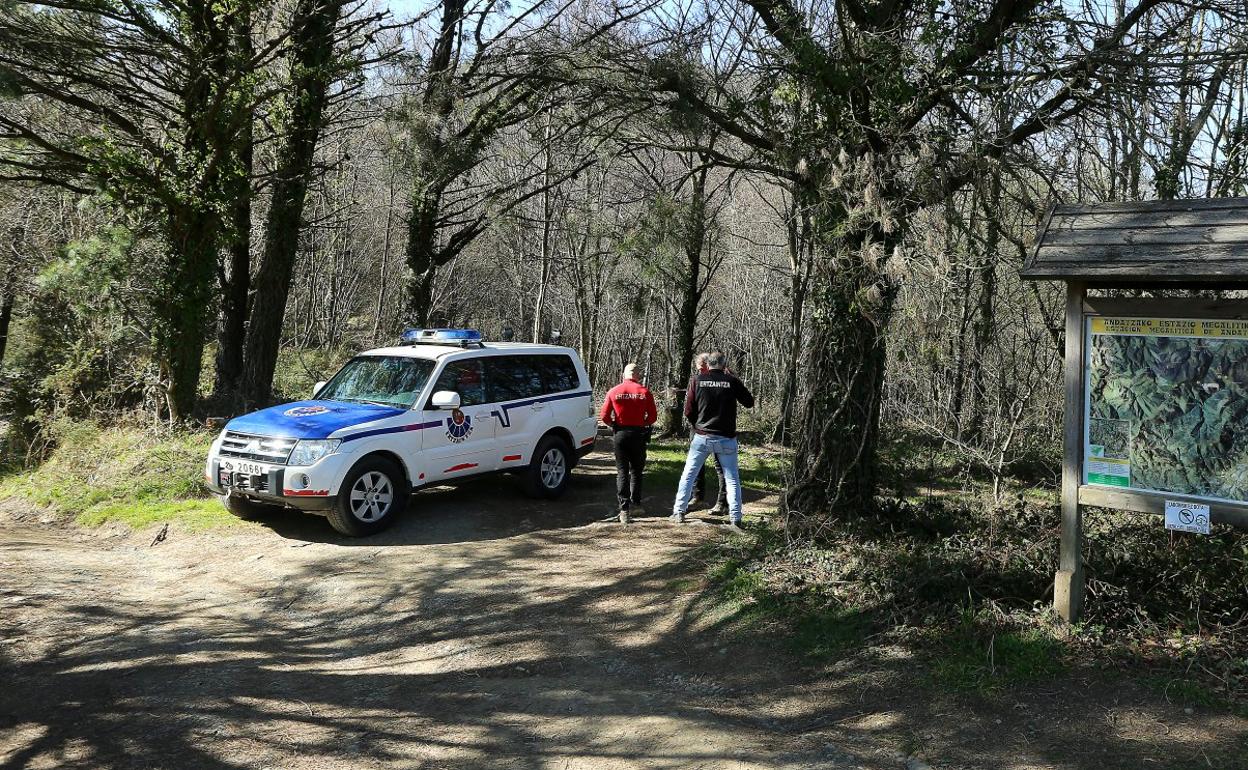 Agentes de la Ertzaintza en el acceso a la zona boscosa donde se halló el cadáver. 