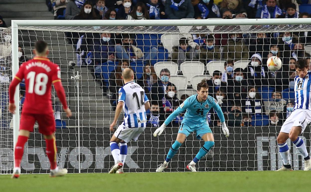 Remiro se lanza a por un balón que pasa por delante de Le Normand. 