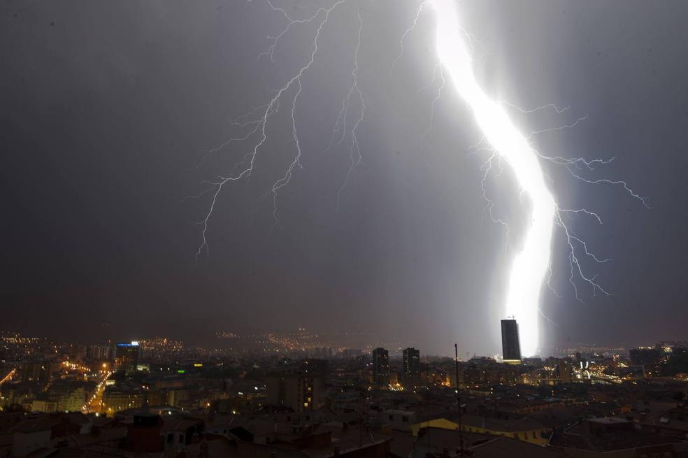 Un relámpago ilumina la torre Iberdrola en Bilbao.