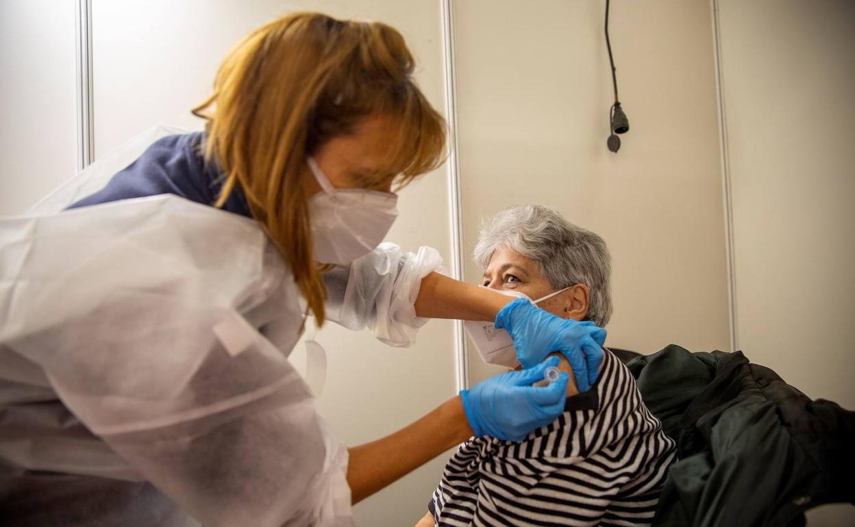 Una mujer recibe la vacuna contra la gripe. 