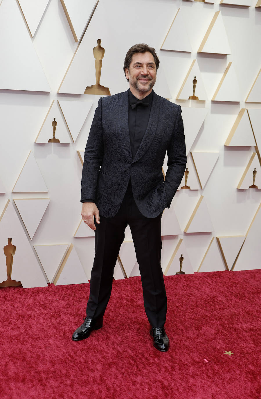 Javier Bardem, nominado a mejor actor por su trabajo en 'Being the Ricardos', ha elegido un esmoquin negro para la ocasión. La americana está creada a partir de un jacquard con estampado de cachemira. Un look sofisticado, elegante y diferente