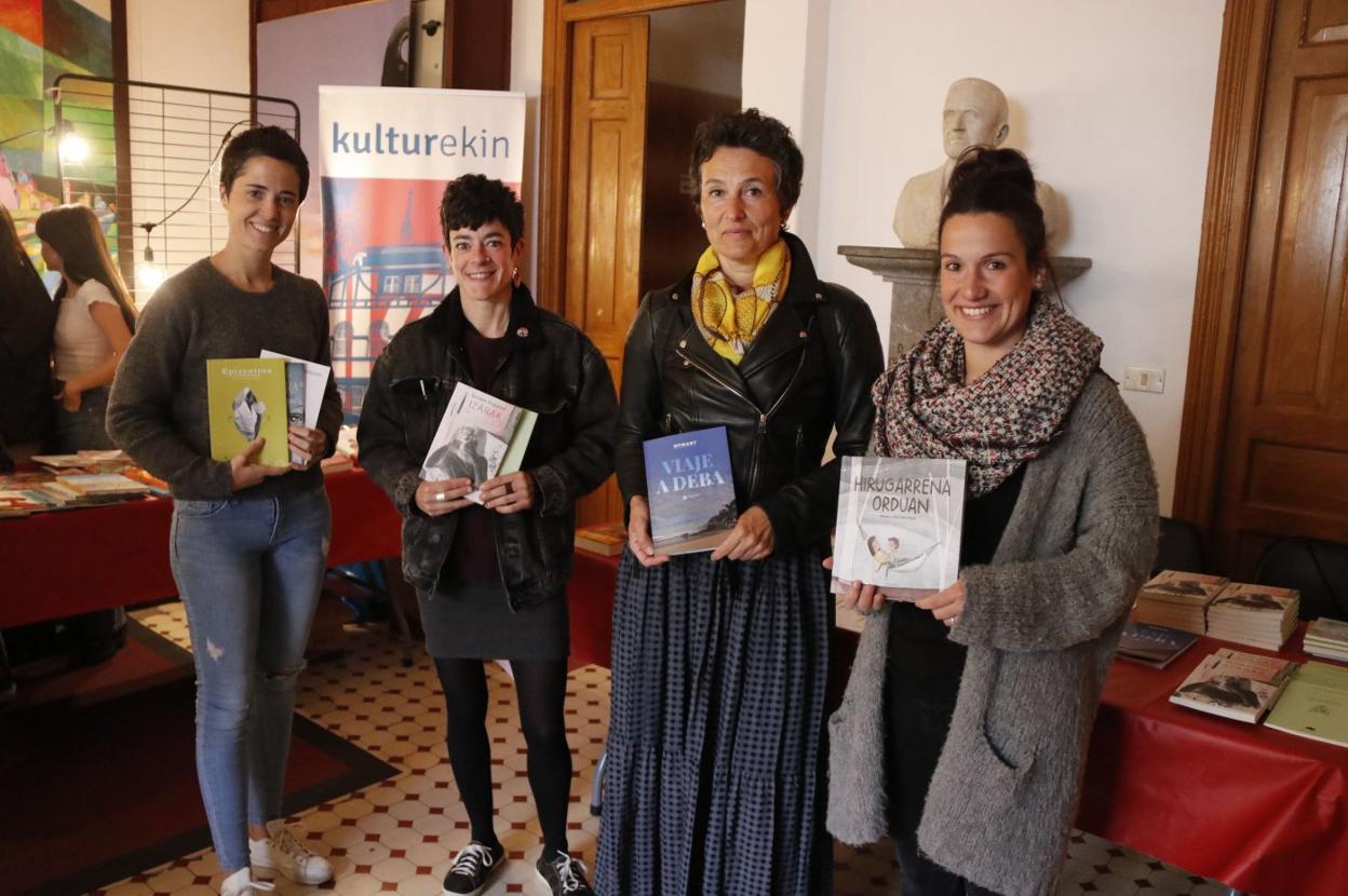 Herriko lau idazleak haien liburuekin. 