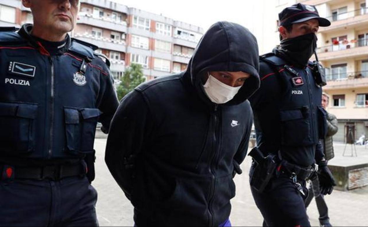 Ertzainas conducen a Nelson David por la calle Bera de Irun hacia su domicilio.