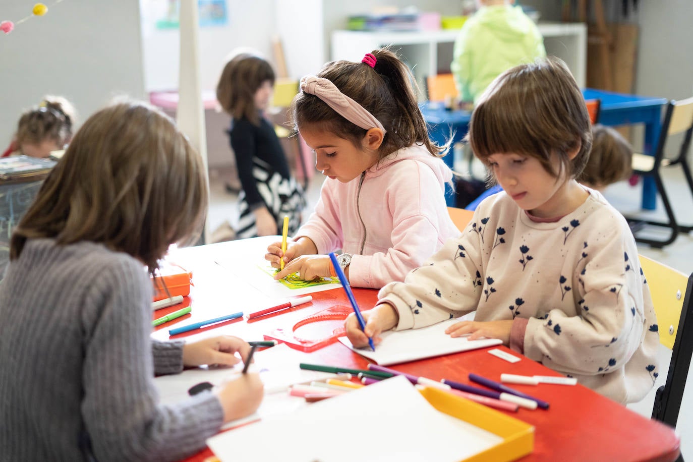 Ikasle gazte batzuk, margotzen eta marrazten.