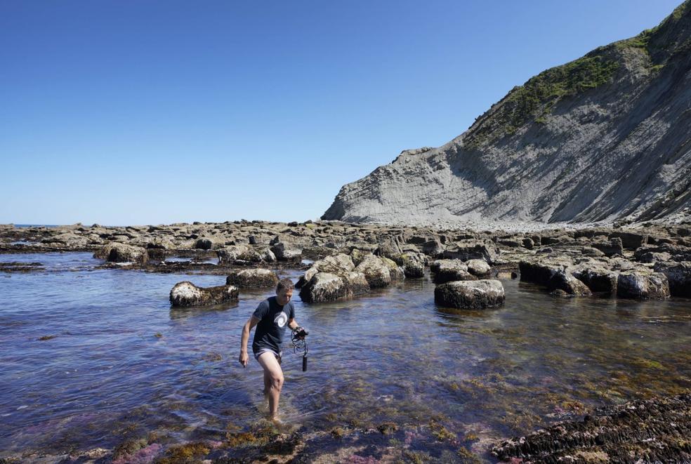 Sergio Seoane, en una zona de algas en la playa de Itzurun (Zumaia), con el medidor de la calidad del agua.