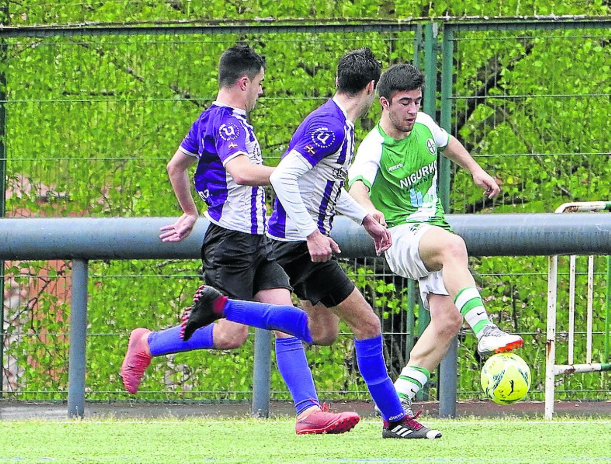 Jugador del Allerrru lucha por el balón entre dos contrarios. 