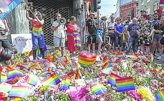 Una multitud de personas protestan por el atentado en un pub gay que acabó con la vida de dos personas, a las que se les dedicó una ofrenda floral. 