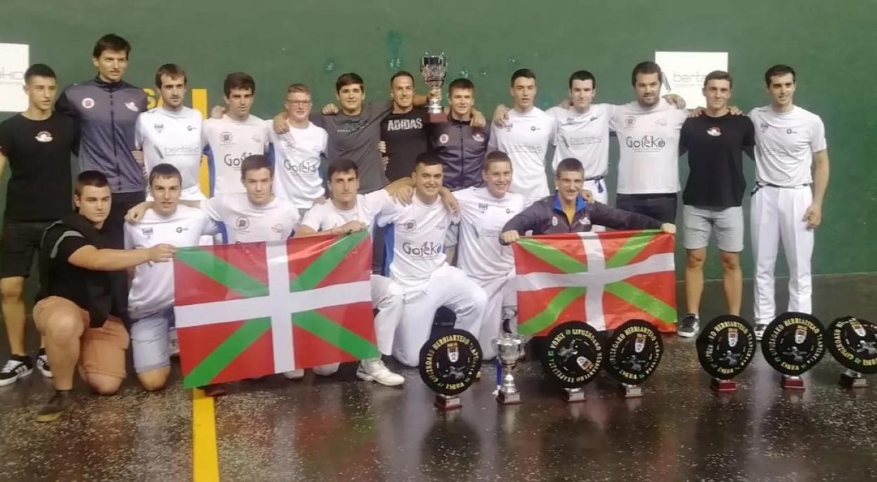 Oiartzungo pilotariak txapelarekin eta kopak goian. 