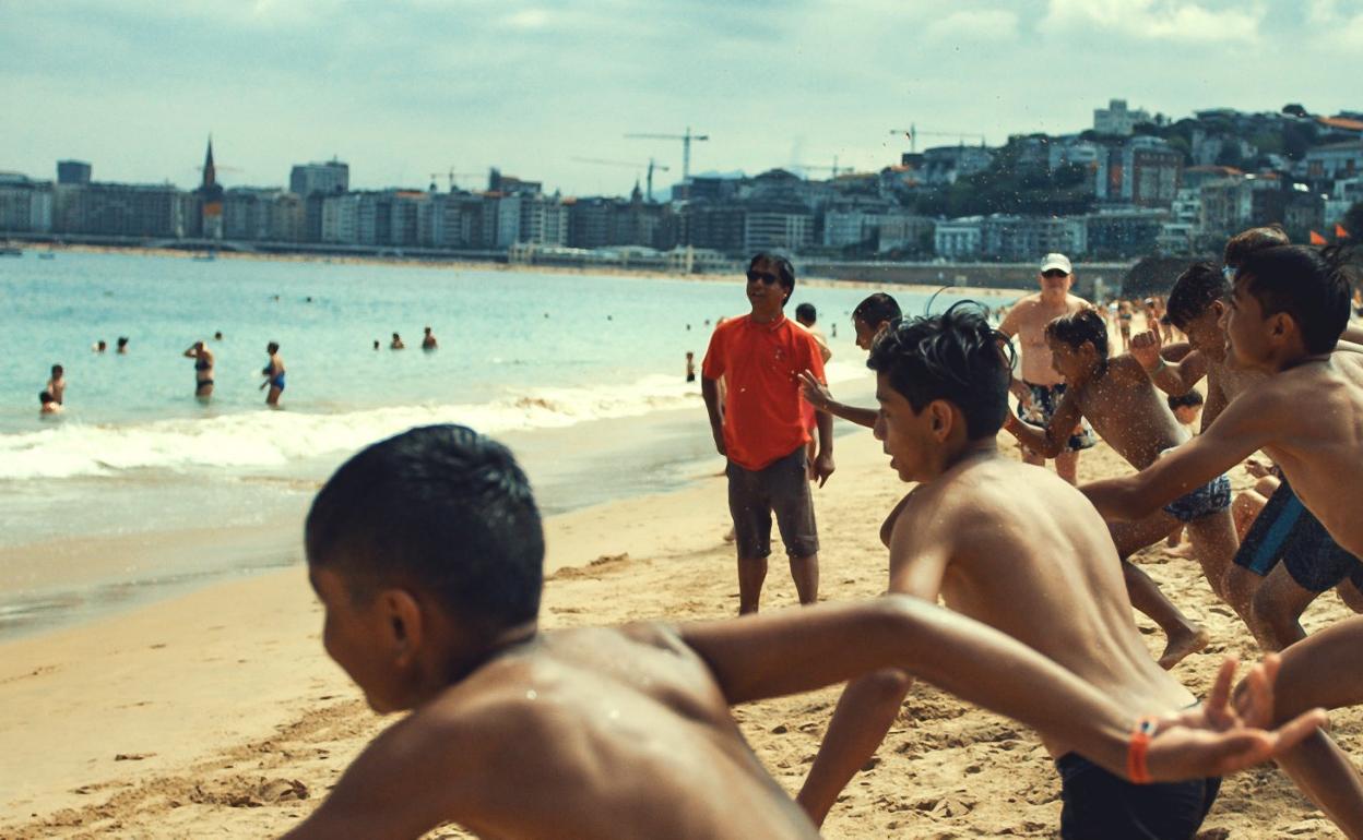 Participantes de la Donosti Cup corren al agua en Ondarreta. 