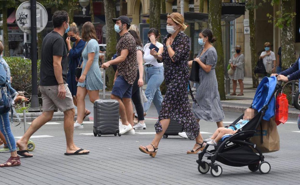 Paseantes este lunes por las calles de San Sebastián.