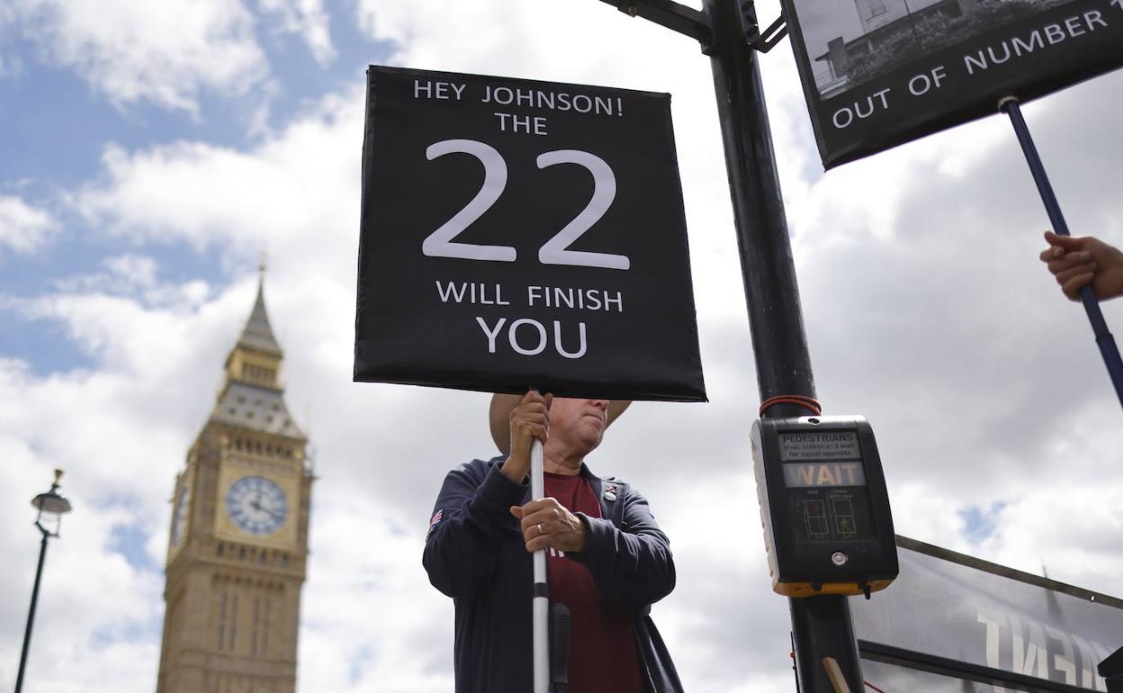 Un hombre protesta contra Boris Johnson este miércoles. El 22 hace referencia al Comité 1922, un órgano interno del Partido Conservador