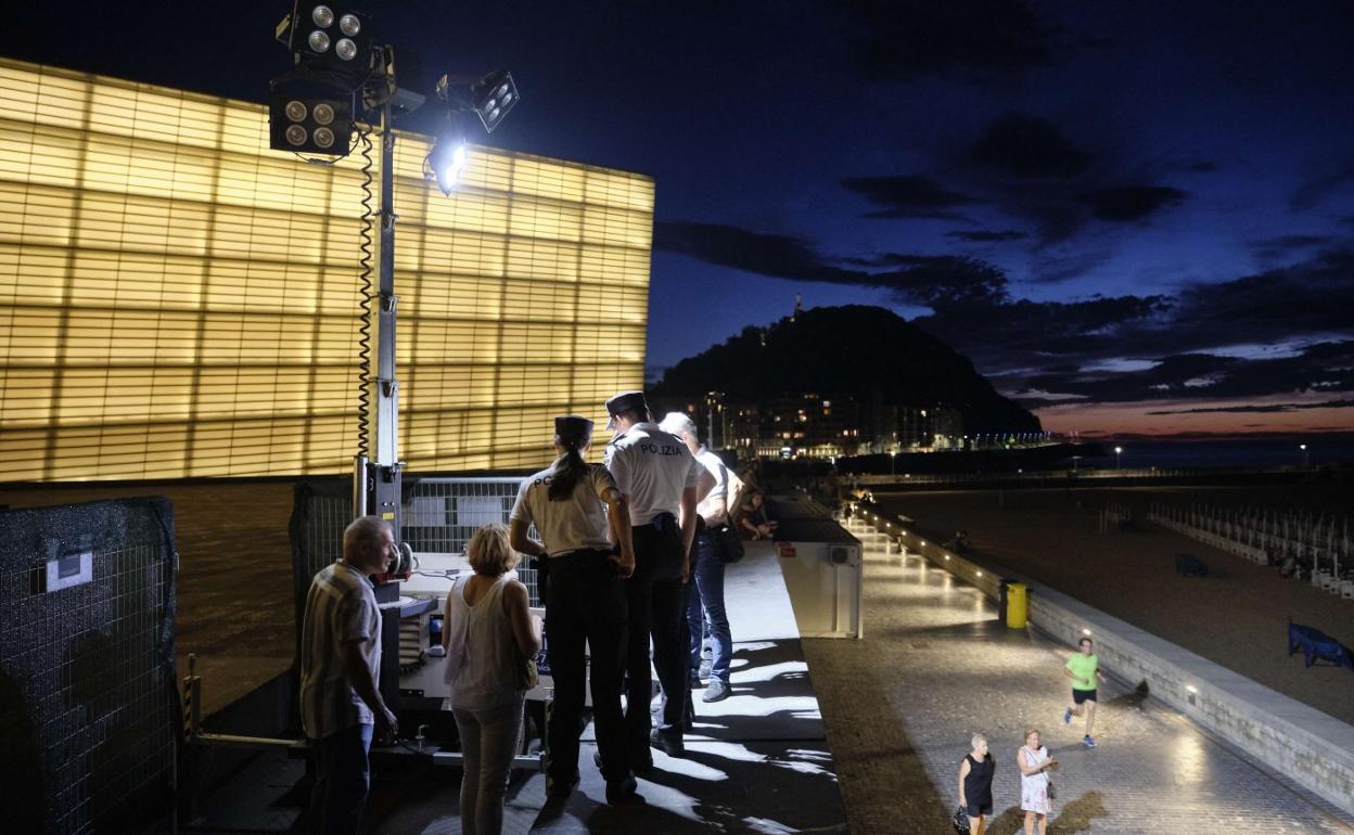 Guardias municipales supervisan el encendido de una de las torres de iluminación que se colocarán detrás del Kursaal. 